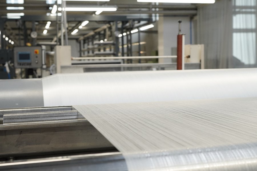 Fluorpolymergewebe beim Abwickeln aus industrieller Webmaschine